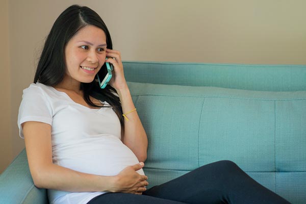 pregnant woman contacting Lifetime Adoption on her phone