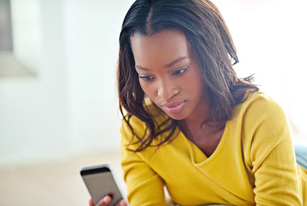 Young African American woman looking at adopttion option app on her phone